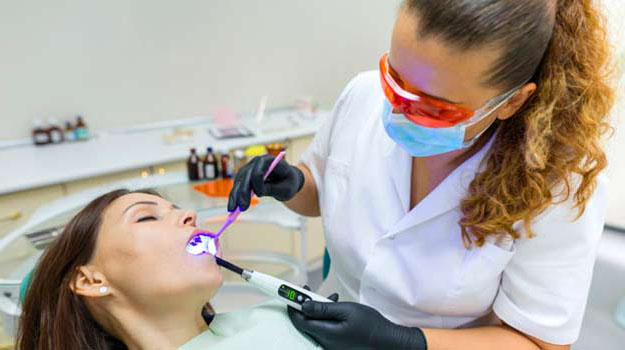 Adult Female Dentist Treating Patient Woman Teeth.